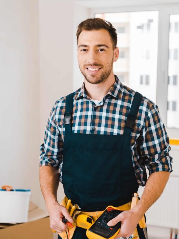 handsome-handyman-smiling-while-holding-digital-multimeter.jpg